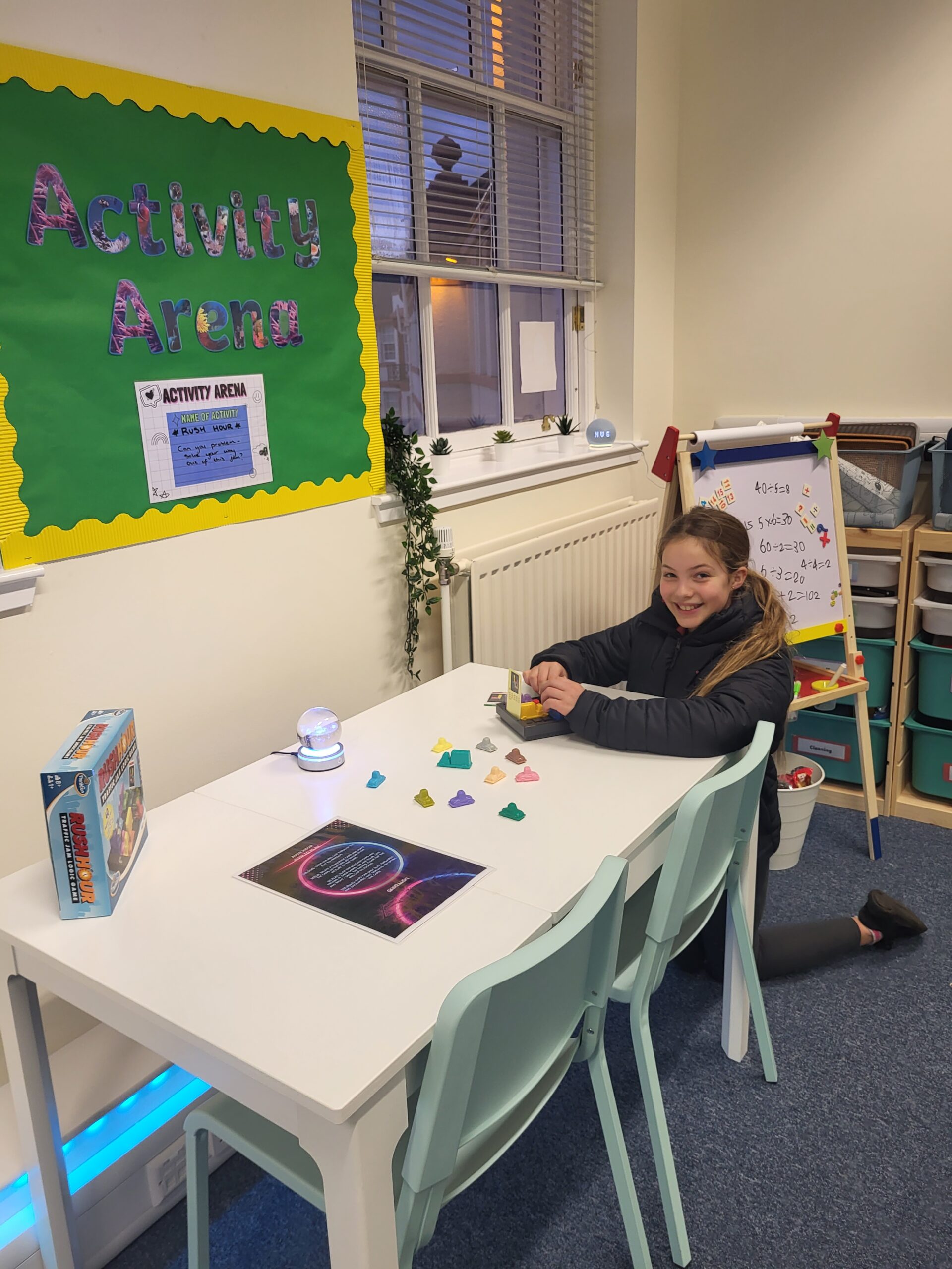 a picture of a female student playing the game rush hour at the activity area in the classroom
