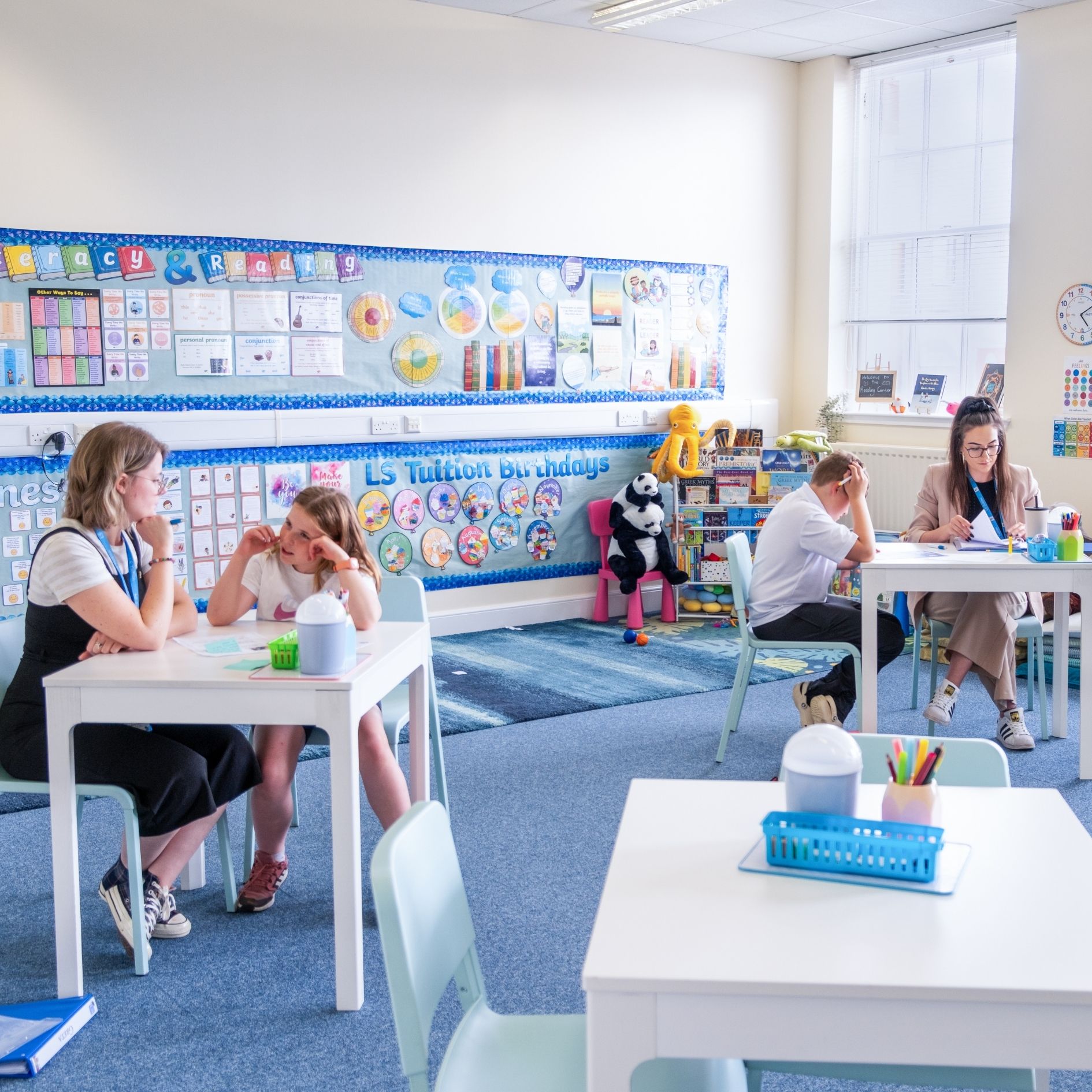 tutors and students sit at desk in lesson time