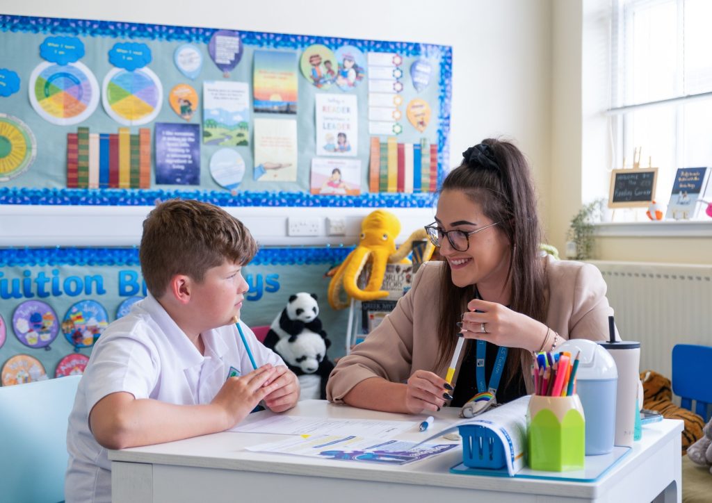 A tutor and student sit at a desk for a weekly tuition lesson